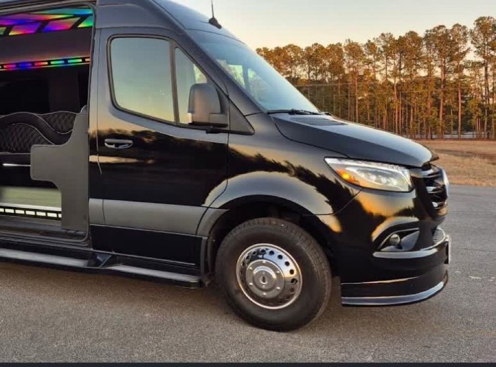 Black Mercedes-Benz Sprinter luxury limousine van, exterior with sliding door open