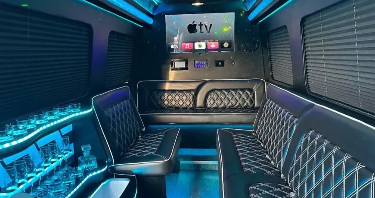 Sprinter limousine interior — quilted leather lounge seating, LED ambient lighting, refreshment bar and screen
