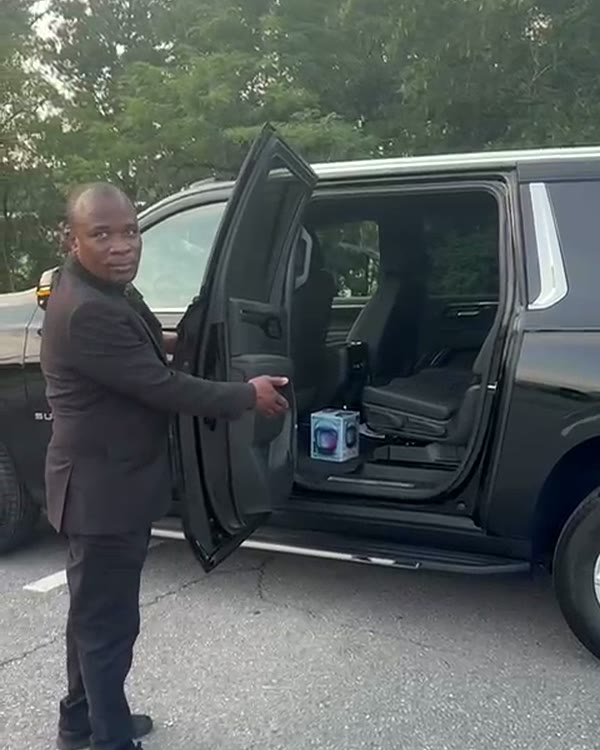 Open rear door of a black SUV showing the second-row passenger seats