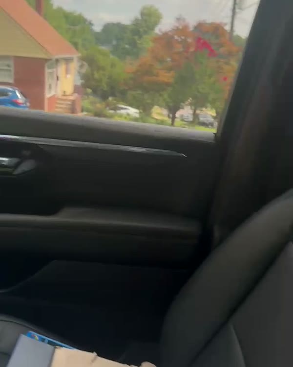 Second-row passenger seat of the black SUV beside a daylit window