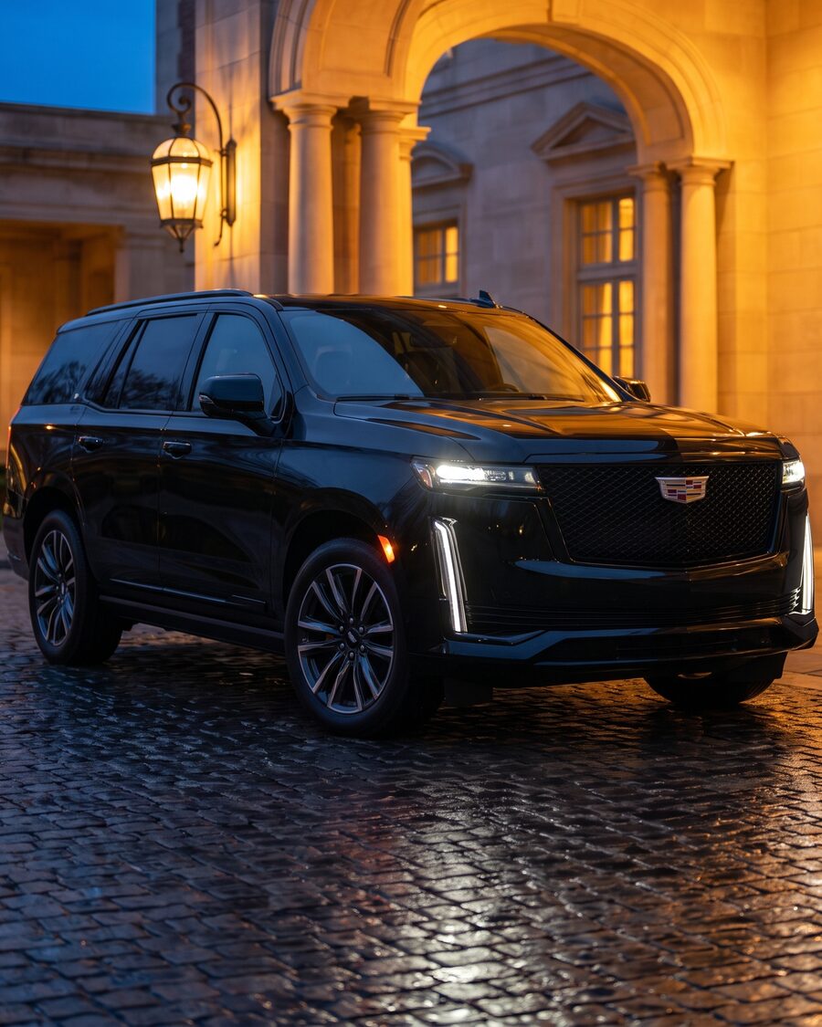 Black 2026 Cadillac Escalade photographed front three-quarter at a lit hotel entrance