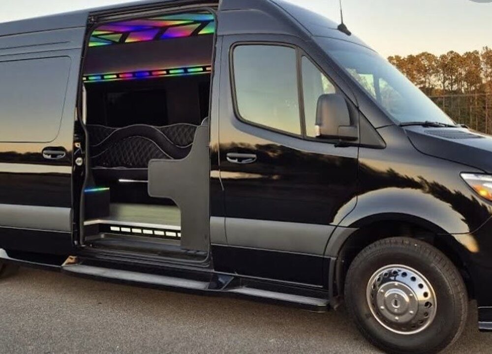 Black Sprinter-style vehicle shown outdoors with its passenger door open